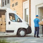 Last-mile delivery courier delivering a package to a business customer.